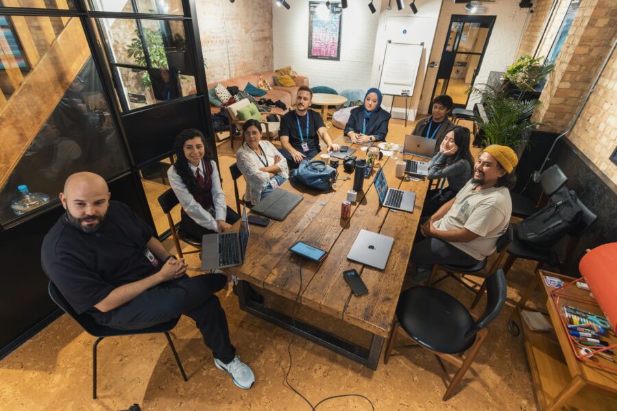 Ondernemer en medewerkers bespreken samen AI-geletterdheid voor ondernemers aan een tafel op kantoor