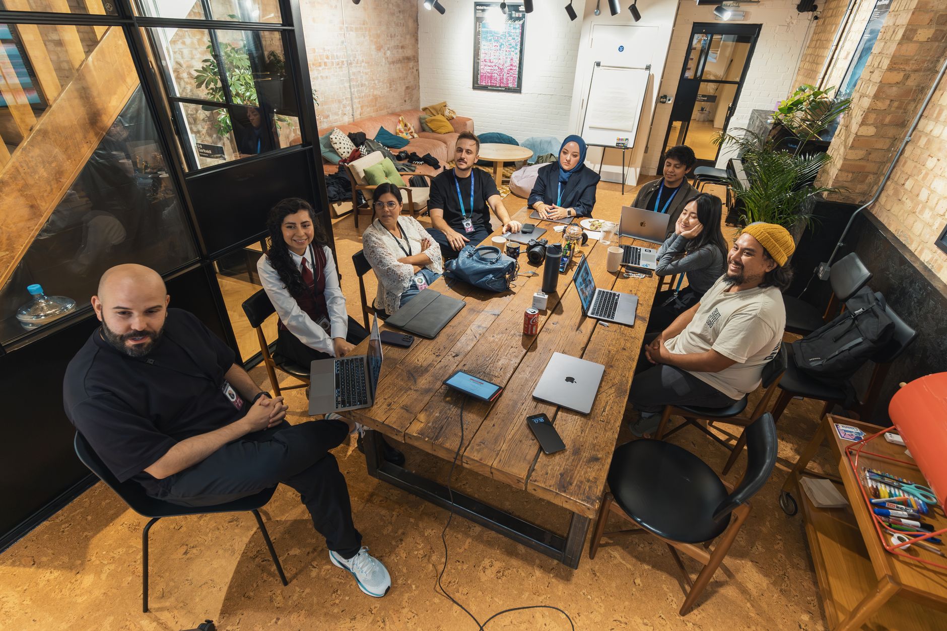Ondernemer en medewerkers bespreken samen AI-geletterdheid voor ondernemers aan een tafel op kantoor