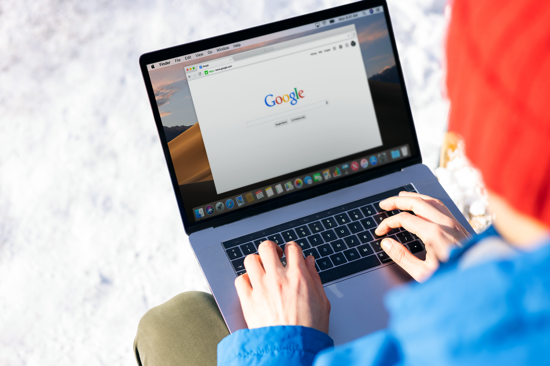 Iemand zoekt informatie op een laptop aan een keukentafel