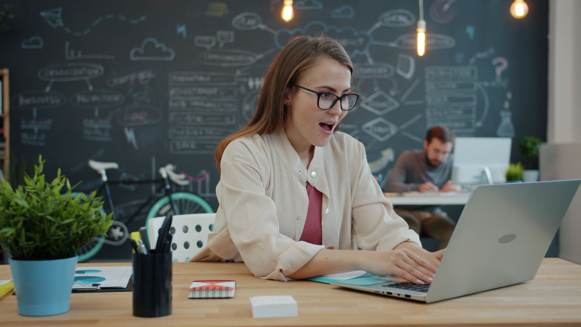 Vrouw aan een bureau die op haar laptop een eigen AI-assistent instelt met vaste instructies