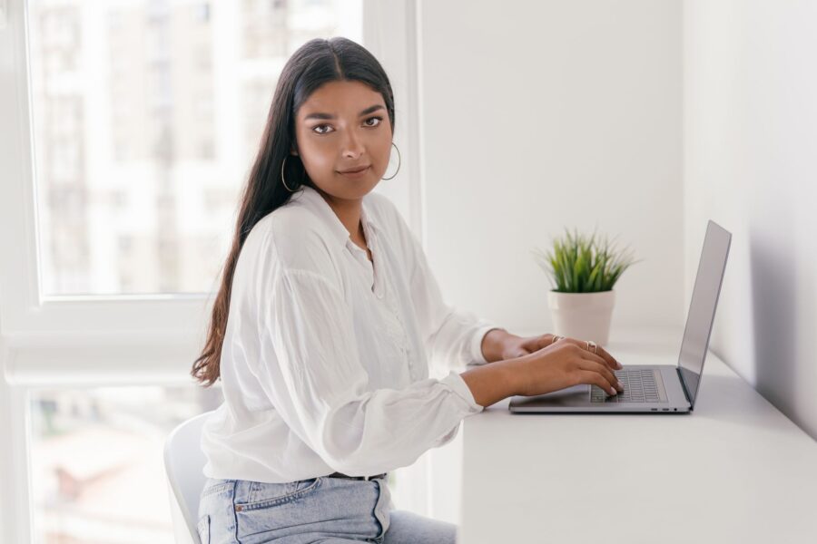 Vrouw probeert gratis AI-tools uit op een laptop aan een bureau