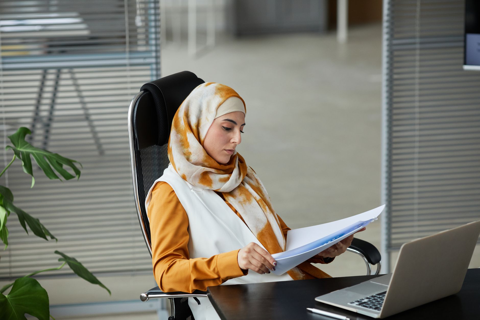 Werknemer aan een bureau leest documenten op een laptop en gebruikt NotebookLM om samenvattingen te maken
