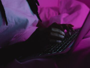 Medewerker aan een bureau met laptop in de avond, terwijl een AI-agent zoals OpenAI Dots het werk overneemt