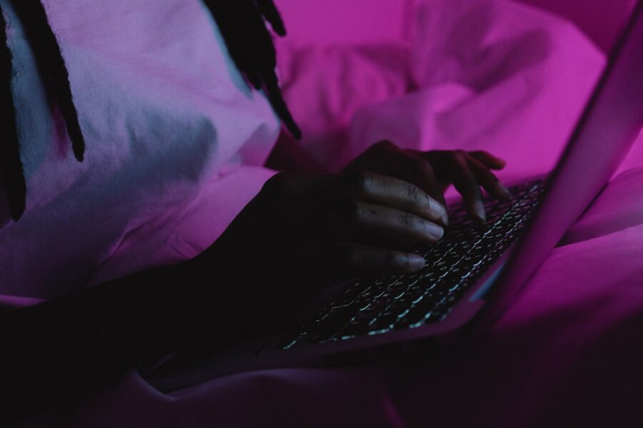 Medewerker aan een bureau met laptop in de avond, terwijl een AI-agent zoals OpenAI Dots het werk overneemt