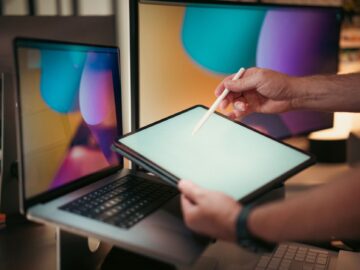 Ondernemer aan een bureau bekijkt een werkstroomschema op een laptop om te kiezen tussen Zapier, Make of n8n